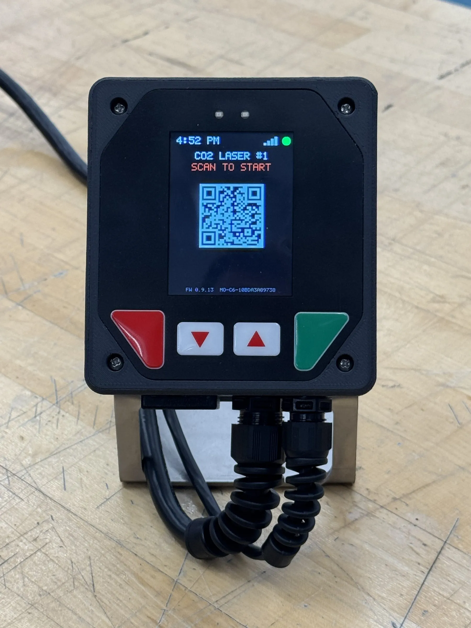 The MakerOps controller on its mounting bracket, showing CO2 Laser #1 and a scan-to-start code
